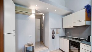 A compact kitchen with white cabinets, a gas stove, and a built-in oven.