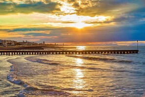A pier extending into the water with a sunset in the background. - Apartment 'Euroholiday 3G' with Balcony and Wi-Fi (Jesolo)