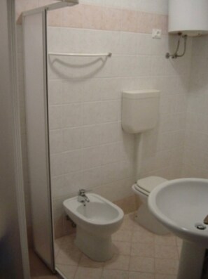 Een badkamer met toilet, bidet en wastafel.