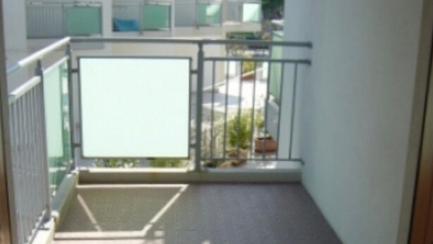 A balcony with a tiled floor, a metal railing, and a view of the outside. - Apartment 'Residence Torino 85' with Shared Pool and Private Terrace (Jesolo)