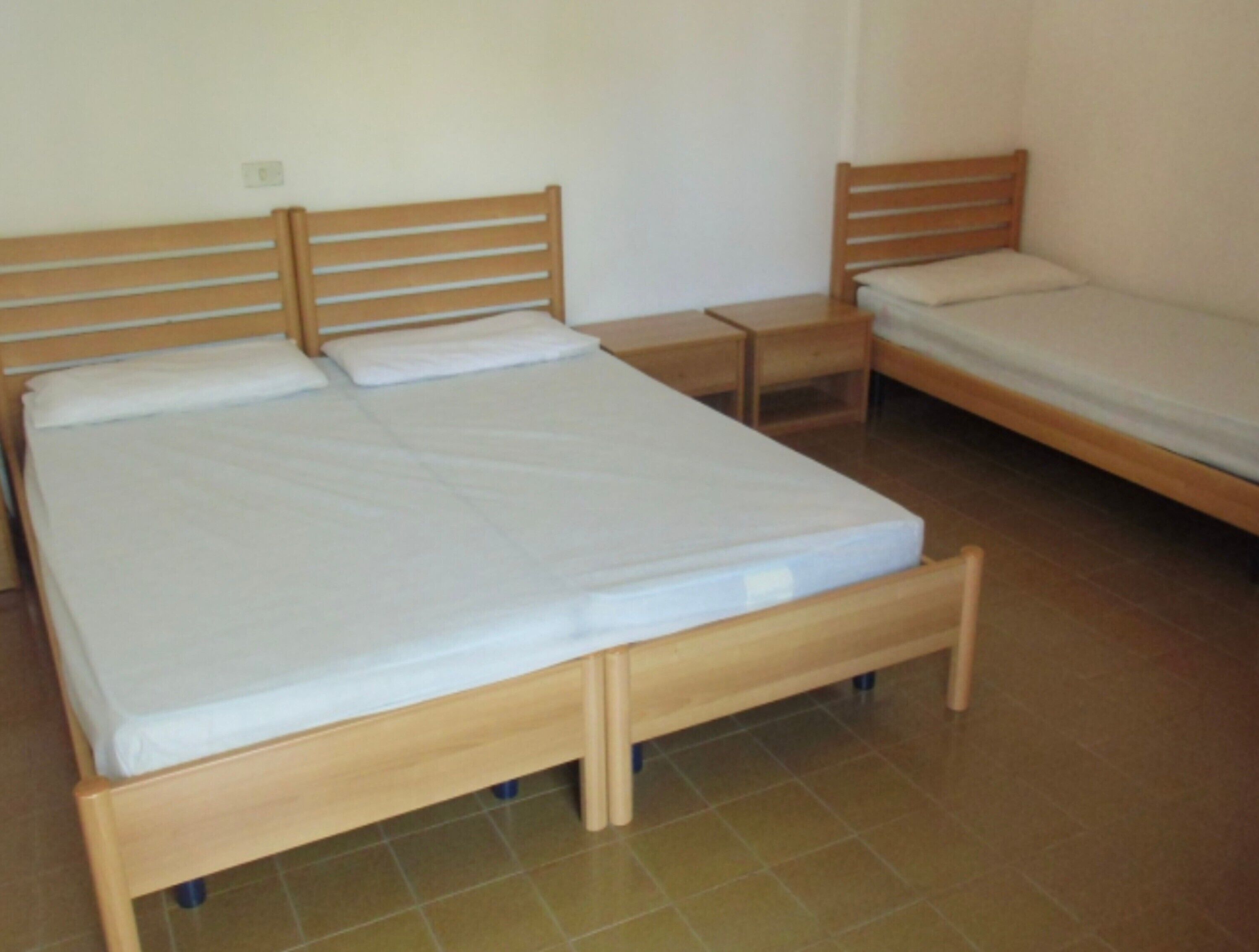 Une chambre à coucher avec un lit en bois, une table de chevet et un plus petit lit.