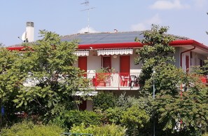 A house with a balcony, solar panels, and a chimney.