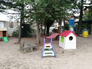 A playground with a slide, a swing, a small house, and a hammock. - Euroholiday Village 2G, Wi-Fi and Air Conditioning (Jesolo)