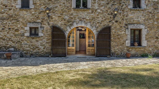 A stone building with a central arched doorway, multiple windows, and a paved entrance area. - Chalet 'El Revolt De Martís' with Private Pool, Private Terrace and Wi-Fi (Martís)