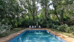 A rectangular swimming pool with a tiled edge, surrounded by lush greenery and trees. - Chalet 'El Revolt De Martís' with Private Pool, Private Terrace and Wi-Fi (Martís)