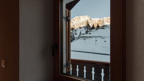 Una habitación con ventana que da a un paisaje montañoso nevado.