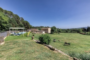 A grassy backyard with a pool, a pergola, and a house in the background. - Holiday Home 'Usall Rural' with Private Pool, Wi-Fi and Air Conditioning (Porqueres)