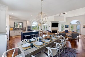 A spacious kitchen with a dining area, white cabinetry, and a large island. - IDEAL IOP Beach Home, 6 BR, Private Pool, Close to Beach, Spacious! (Isle Of Palms)