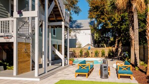 Un jardin avec une piscine, du mobilier d’extérieur et une terrasse en bois.