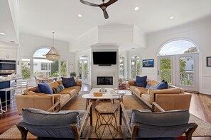 A spacious living room with a fireplace, comfortable seating, and large windows. - IDEAL IOP Beach Home, 6 BR, Private Pool, Close to Beach, Spacious! (Isle Of Palms)