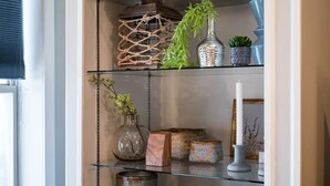 A shelf with decorative items including a plant, a vase, and a candle. - THE SKYSCRAPER IN HEART OF COLUMBUS (Columbus)