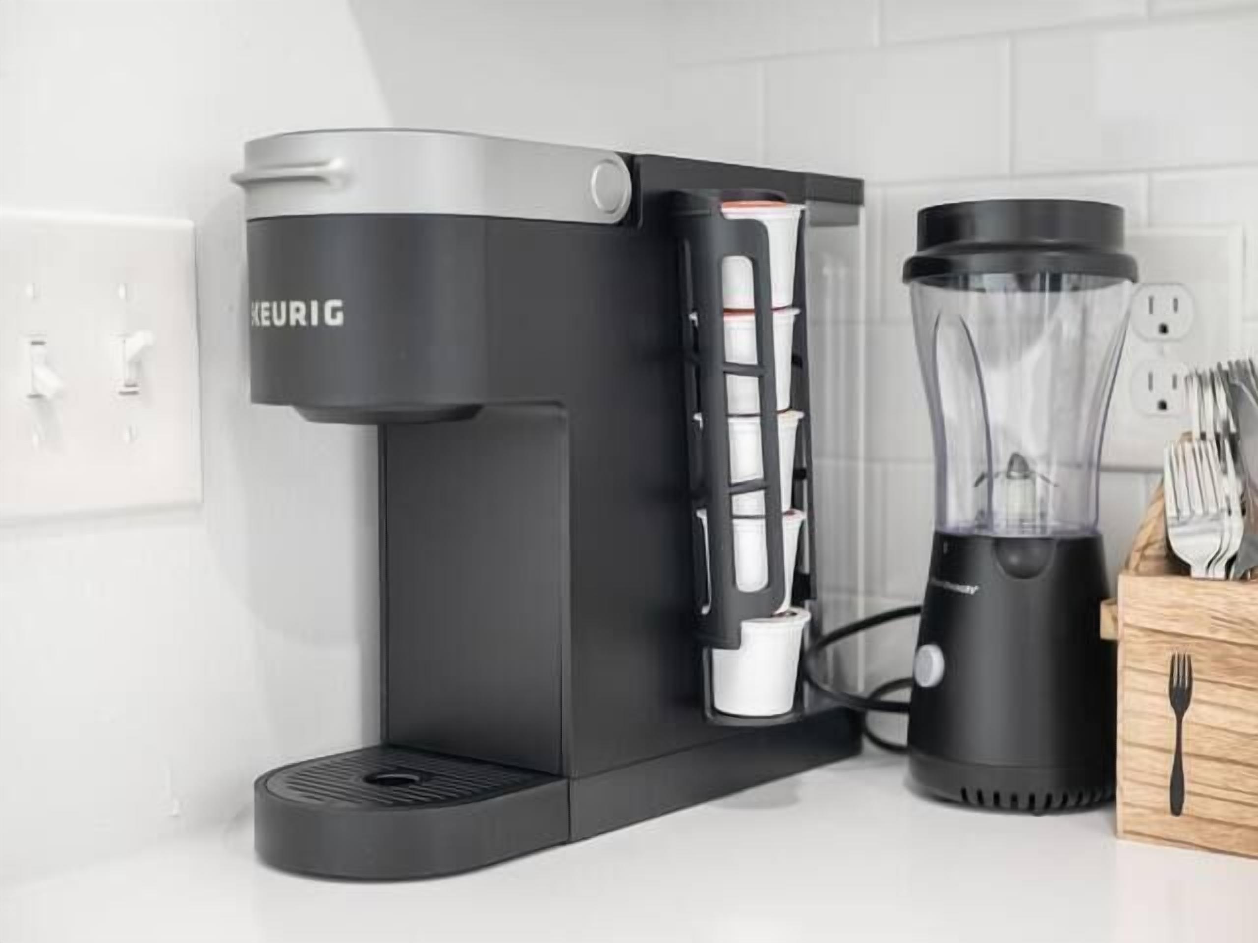 Eine Kaffeemaschine mit integriertem Mahlwerk und ein Mixer auf einer Küchenarbeitsplatte.