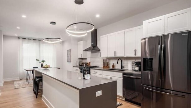 A modern kitchen with a central island, stainless steel appliances, and pendant lighting. - Oak Street Rooftop - Columbus! (Columbus)