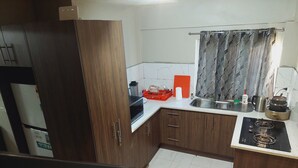 A kitchen with wooden cabinets, a countertop, a stove, and a sink.