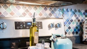 A kitchen with a stainless steel stove, a blue kettle, a bottle of olive oil, and salt and pepper shakers on the counter. - DUBLIN GETAWAY - NEAR COLUMBUS! (Dublin)