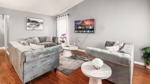 A modern living room with two grey sofas, a white coffee table, and a ceiling fan. - DUBLIN GETAWAY - NEAR COLUMBUS! (Dublin)