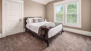 A bedroom with a bed, a ceiling fan, a window with blinds, and a door. - Perfect Stay - 2 Bedrooms - Columbus! (Columbus)