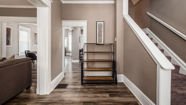 A hallway with a staircase, wooden flooring, and a framed picture on the wall. - Perfect Stay - 2 Bedrooms - Columbus! (Columbus)