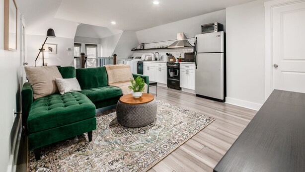 A modern kitchen with white cabinets, a black stove, and a white refrigerator. - Columbus Getaway! Stylish Apartment! (Columbus)