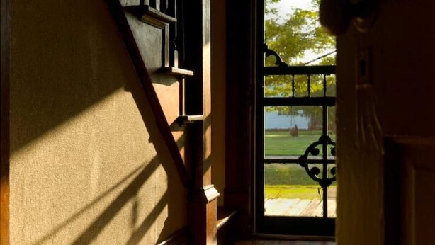 A staircase leading to a door with a view of a grassy area outside. - Garden View Lodge (Lucas)