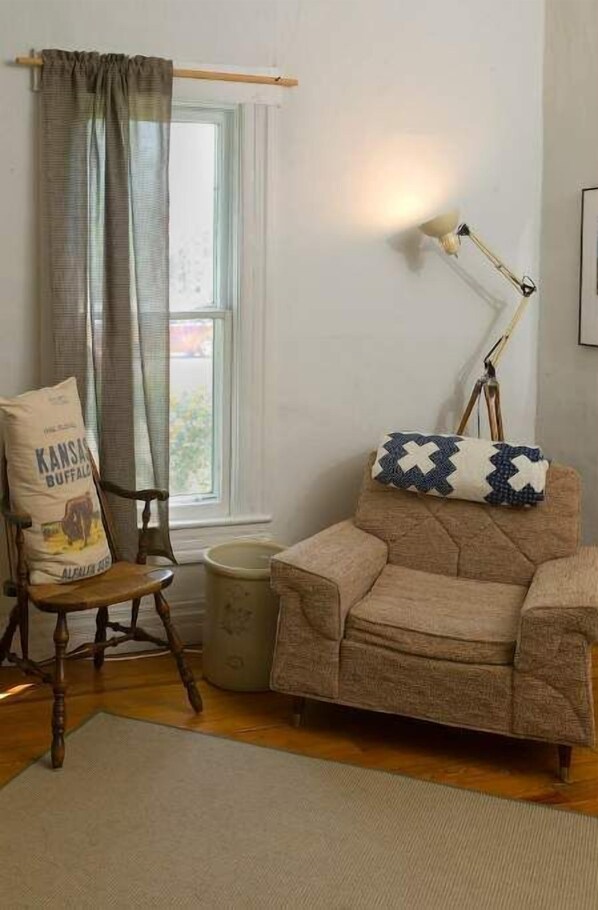 Relax in a cozy corner with a vintage armchair and a wooden chair, both paired with comfortable cushions.