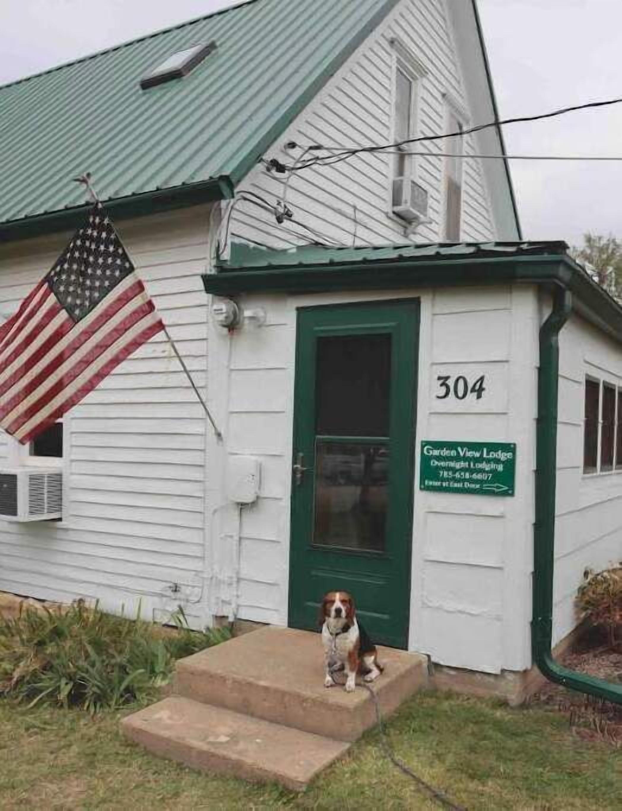 A white building with a green door and a number 304 sign.