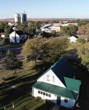 Surrounded by a serene lawn and trees, this house offers a peaceful rural retreat.