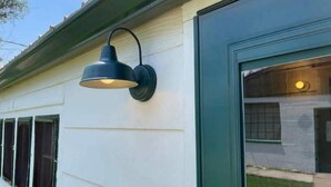 A building with a dark green exterior and a single window with a black frame. - Garden View Lodge (Lucas)