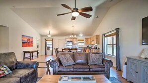 A spacious living room with a leather sofa, a wooden coffee table, and a ceiling fan. - Moab Oasis among the Redrocks! (Moab)