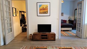 Ein Wohnzimmer mit Fernseher, einem gemusterten Teppich und einer Couch.