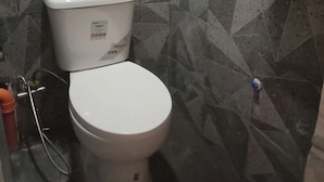 A bathroom with a toilet, a hand dryer, and a shower area. - TerisitaPlace - Love At First (Taytay)
