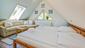 Une chambre à coucher avec un lit, un canapé, une fenêtre et un radiateur.