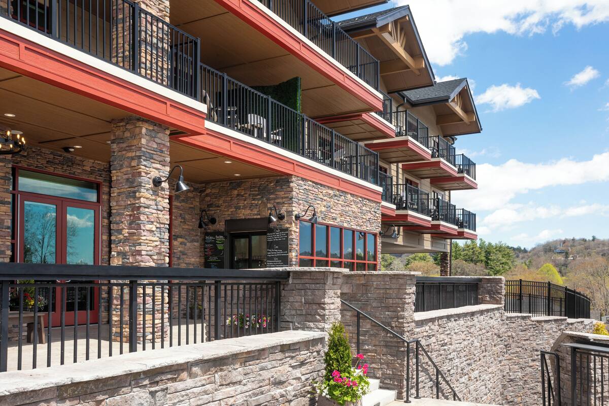 A multi-story building with stone facade, balconies, and a stone staircase.