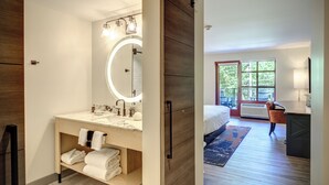 A modern bathroom with a large mirror, a sink, and a towel rack.