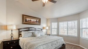A bedroom with a bed, nightstands, a ceiling fan, and windows with blinds. - Homestead Haven | Sleeps 14 | 2 Car Garage (Clearfield)