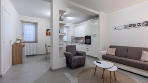 Een modern appartement met een woonkamer, eetgedeelte en keuken.