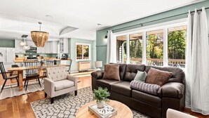 Ein modernes Wohnzimmer mit Sofa, Couchtisch und Essbereich.