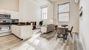 Eine moderne Küche mit weißen Schränken, einer eingebauten Mikrowelle und einer großen Kochinsel.