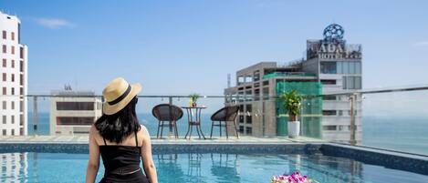 Una piscina al aire libre, sillones reclinables de piscina