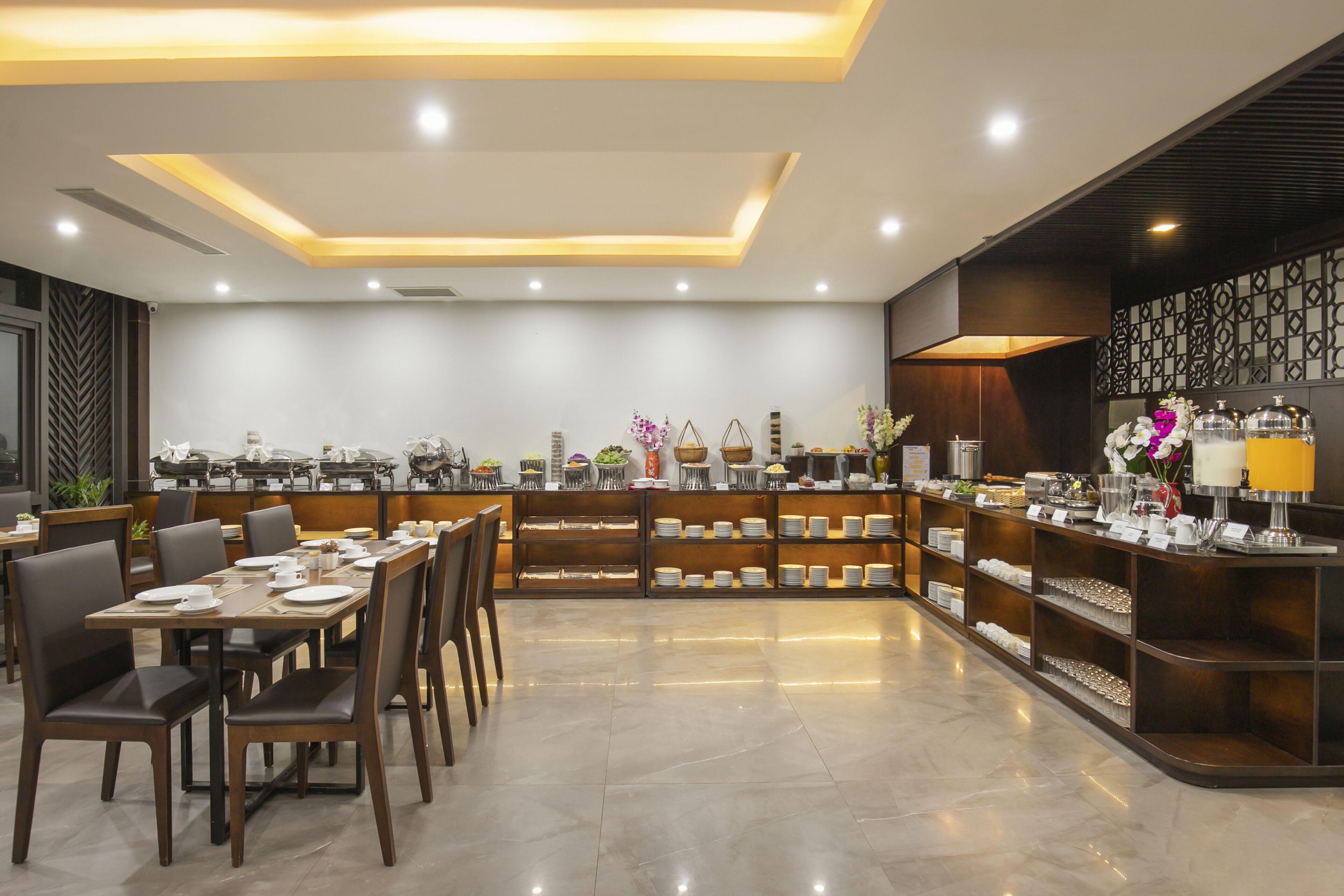 Un comedor moderno con una barra larga, diversas opciones de asientos y una variedad de exhibiciones de comida y bebidas.