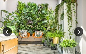 A hotel room with a herringbone floor, a wooden bed, two orange chairs, and a wall covered with various plants. - Ivy House, 6-Beds, Sleeps 19 with Hot Tub (Doncaster)