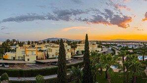 A residential area with modern buildings, a parking lot, and a clear view of the sunset. - SunRays  Naturist Apartment in Playas de Vera (Playas de Vera)