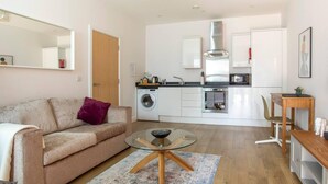 Un appartamento moderno con zona living, angolo cottura e sala da pranzo.