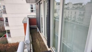 A balcony with a wooden floor, large sliding glass doors, and a metal railing. - Free parking near city centre & stadium sleeps 6-8 (Leicester)