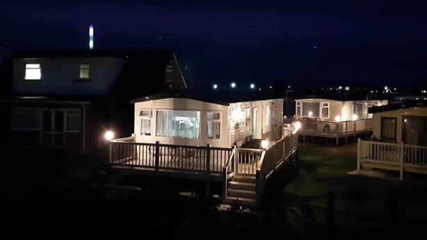 A row of mobile homes with a central building featuring a large window and a balcony.