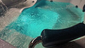 A hot tub with a clear blue water feature, a wooden bowl, and a tiled wall in the background. - Soothing 4-bedroom house with WiFi in Medellín (Medellín)