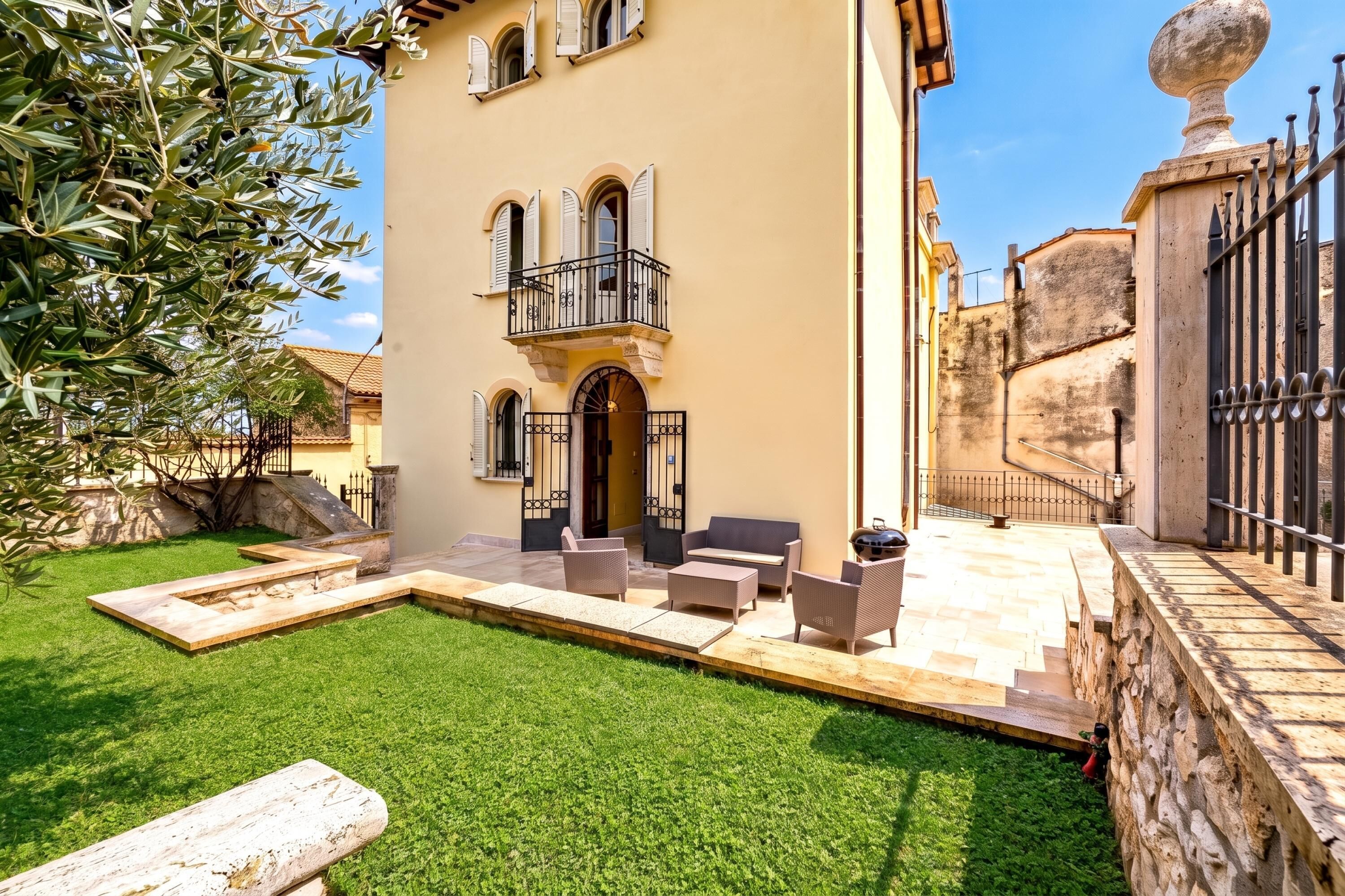 Un edificio con patio, mesas al aire libre y una pared de piedra.