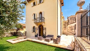 Un edificio con patio, mesas al aire libre y una pared de piedra.