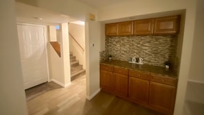 Una cocina con armarios de madera, salpicadero de azulejos y encimera.