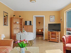 A living room with a round table, a television, and a bookshelf. - Waterkant by Interhome (Zinnowitz)